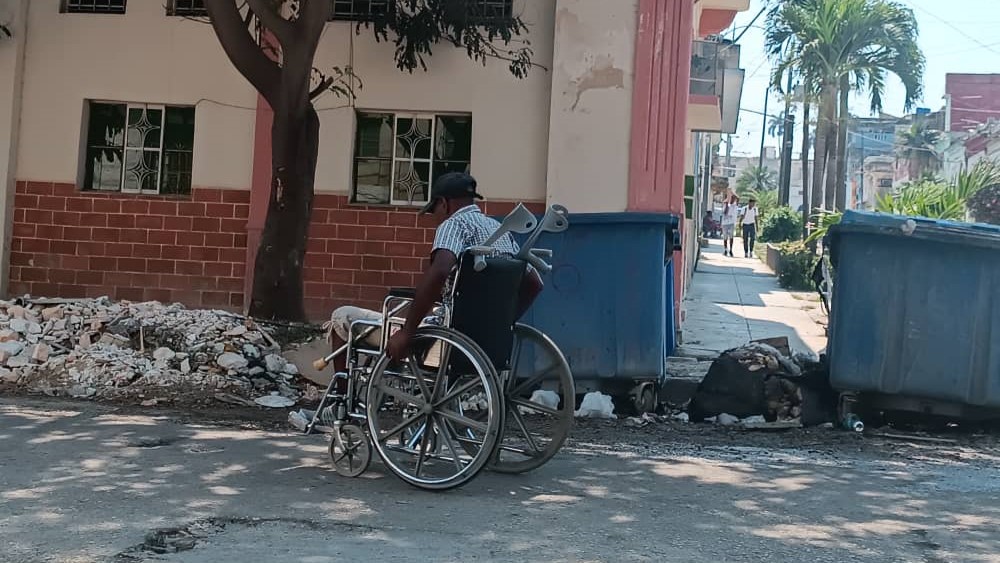Un hombre en silla de ruedas por una calle de La Habana.