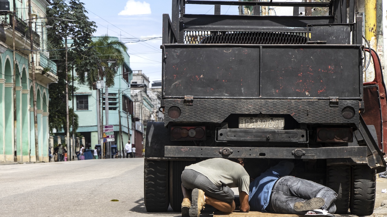 Dos hombres arreglando un camión en La Habana.