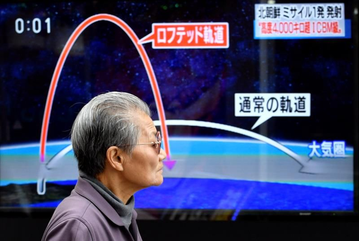 Un hombre frente a un televisor que muestra detalles del lanzamiento de un misil balístico de Corea del Norte.