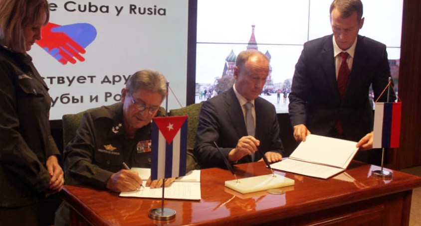 Secretario de Defensa ruso Nikolái Pátrushev (D) y Julio Gandarilla, ministro del Interior cubano, firman el memorando.