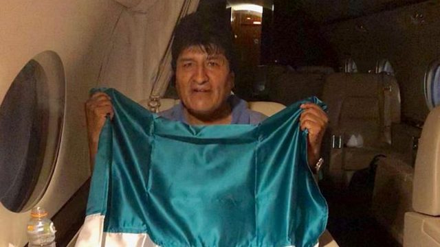 Evo Morales con una bandera mexicana en el avión que lo llevara a México.