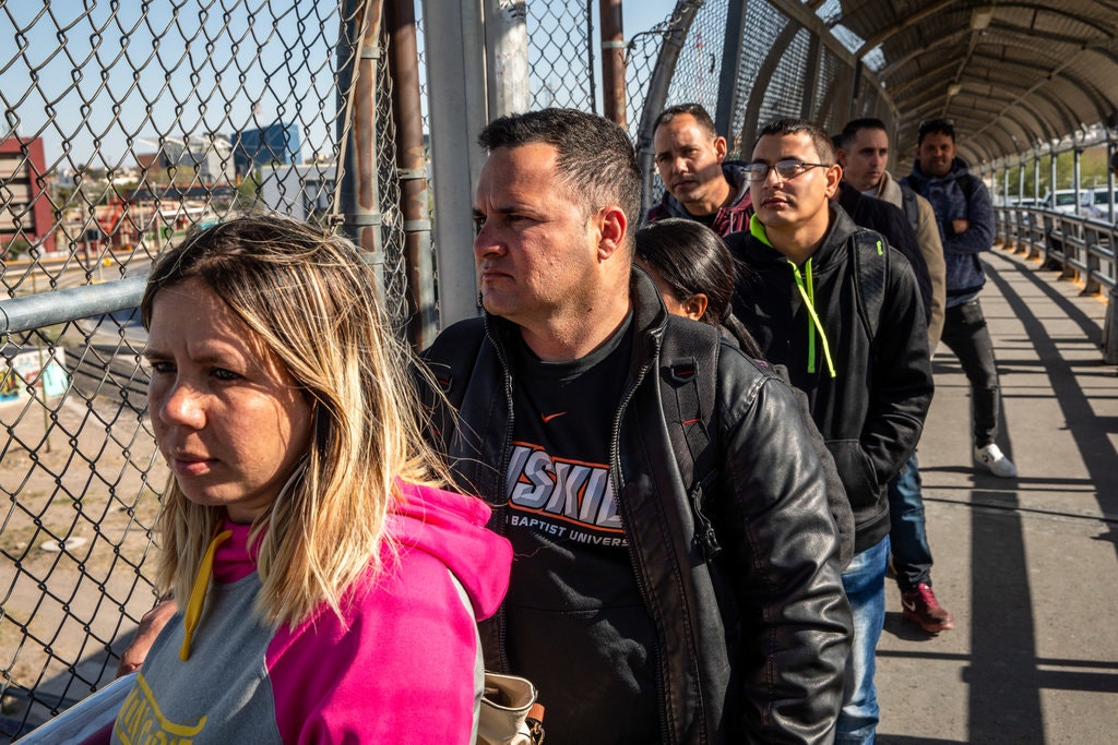 Solicitantes de asilo cubanos esperan en fila para cruzar a EEUU desde Ciudad Juárez, México.