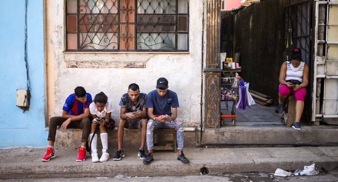 Cubanos conectados con sus teléfonos móviles.