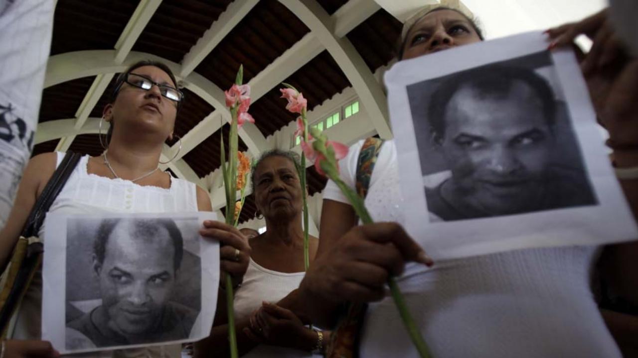 Las Damas de Blanco muestran fotografías de Orlando Zapata Tamayo durante una de sus marchas en 2011.