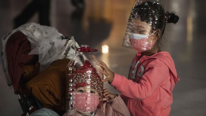 Dos niños chinos con máscaras improvisadas en el aeropuerto de Pekín.