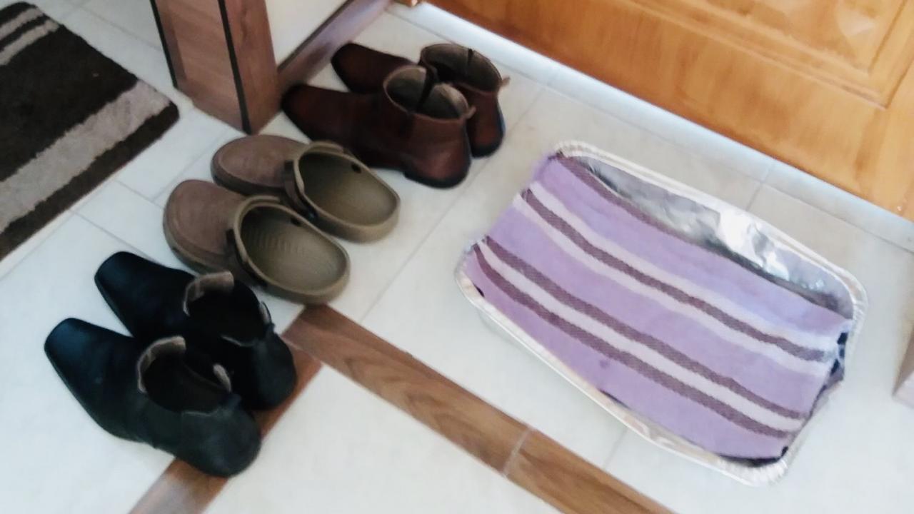 Los zapatos del esposo de Delia, en la puerta de su casa para ser desinfectados. 