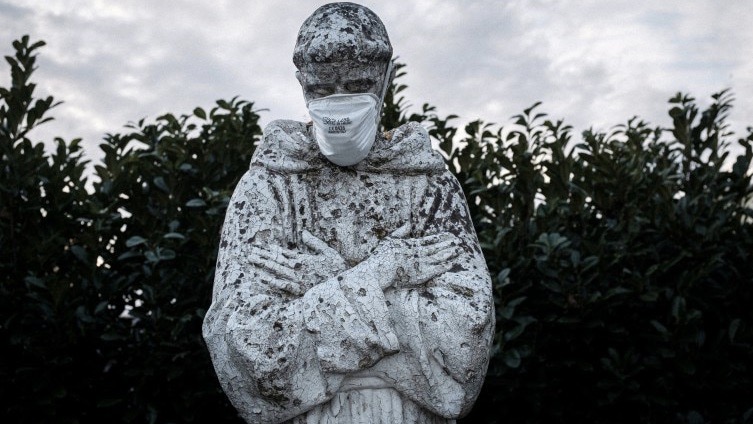 Estatua de San Francisco, cubierto con una mascarilla en San Fiorano, Italia.