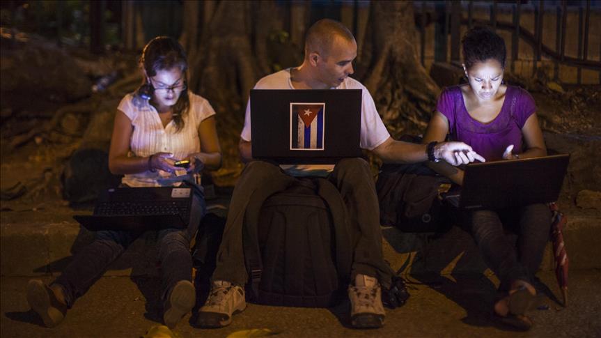 Cubanos conectados a WiFi en la oscuridad de un parque.