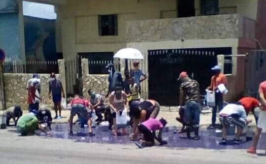 Un grupo de cubanos recoge detergente del suelo en una calle de San Miguel del Padrón.