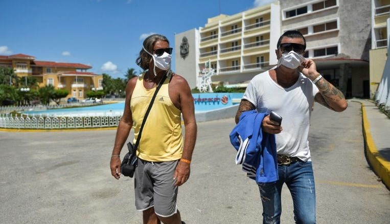 Dos extranjeros en La Habana con nasobuco.