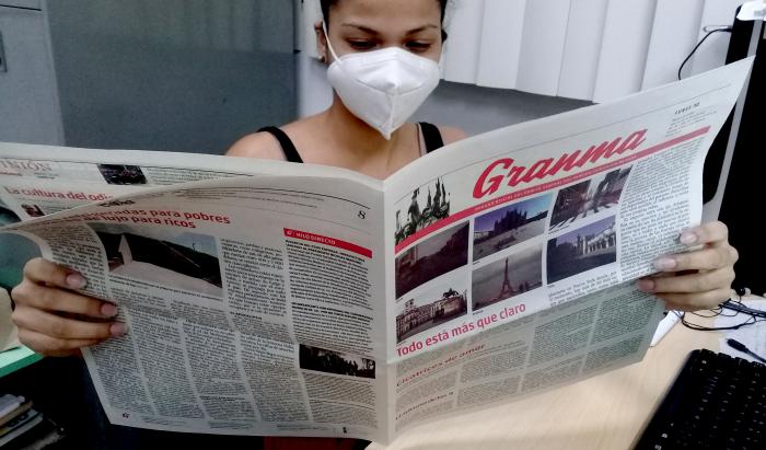Una cubana con una edición del diario 'Granma' en colores.