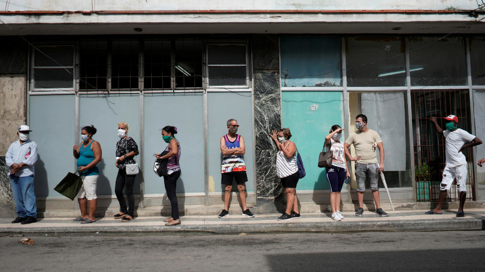 Cubanos hacen una cola durante la pandemia del coronavirus.