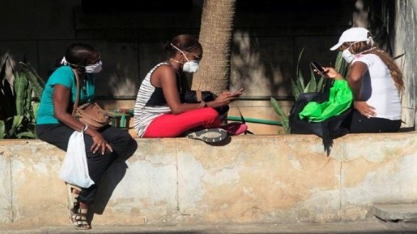 Cubanas conectadas a internet en un lugar público.