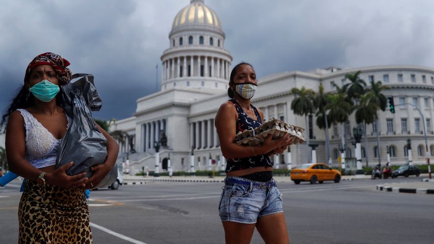 Dos mujeres con víveres frente al Capitolio de La Habana.