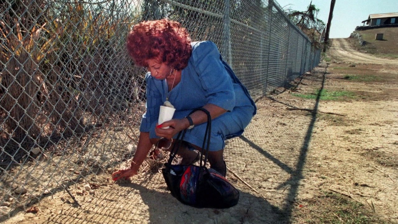 Celia Cruz recoge tierra cubana desde la Base Naval de Guantánamo.