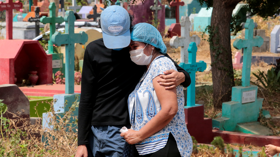 Dos personas asisten al funeral de un hombre que se cree falleció por coronavirus en Nicaragua.