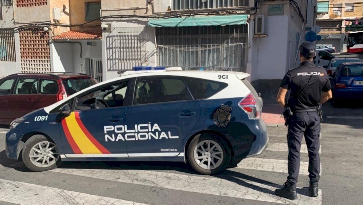 Policía Nacional de España frente a un edificio.