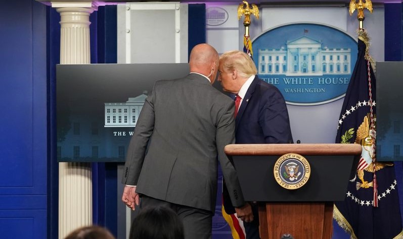 Donald Trump habla con un agente del Servicio Secreto antes de abandonar la rueda de prensa sobre coronavirus en la Casa Blanca.