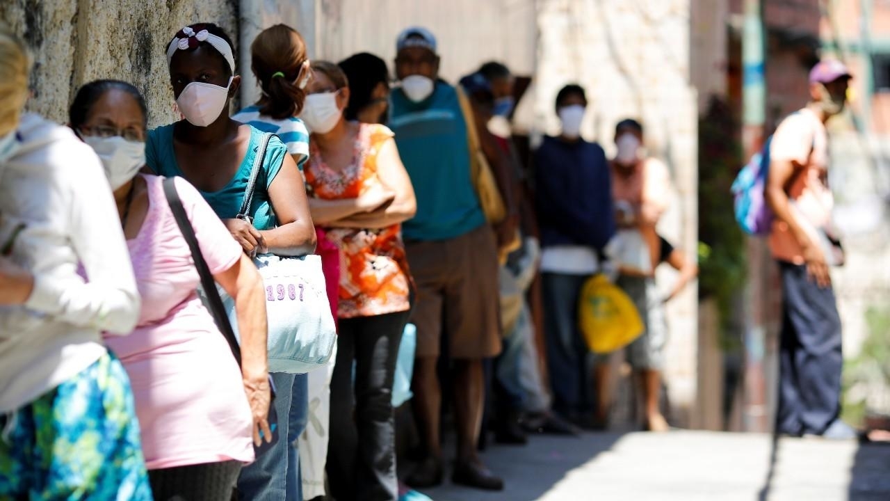 Un grupo de personas hace fila para recibir alimentos de una organización benéfica en Caracas.