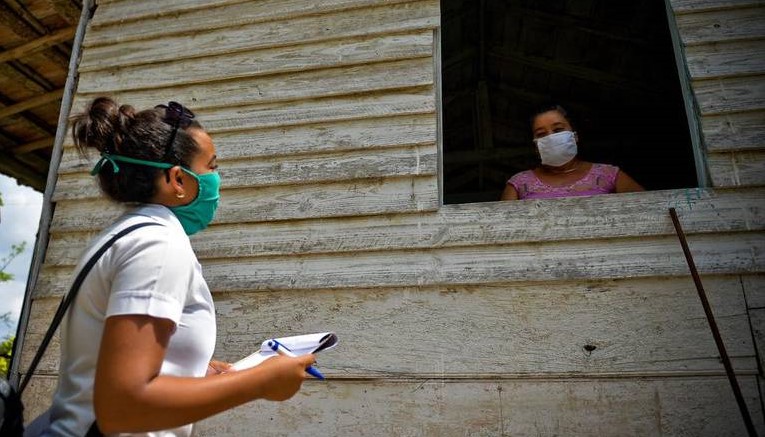 Una mujer recibe una visita de una profesional de la salud.