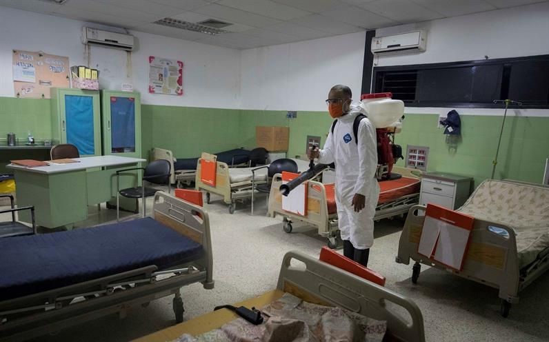 Un sanitario desinfecta una sala en un hospital de Venezuela.
