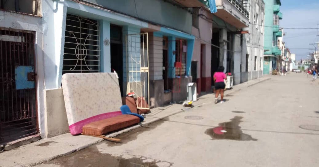 Afectados por las inundaciones en el barrio habanero La Victoria secan sus colchones al sol. 