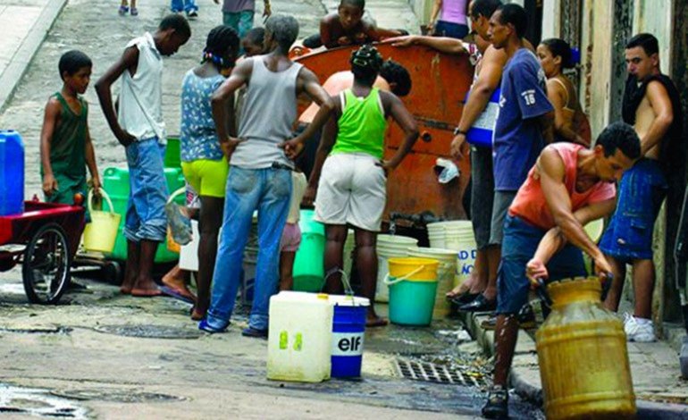 Cubanos cargan agua en la ciudad.