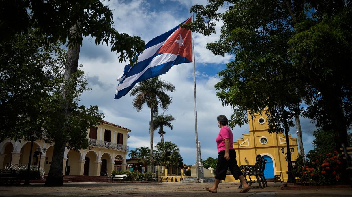 Una mujer cubana camina por un parque.