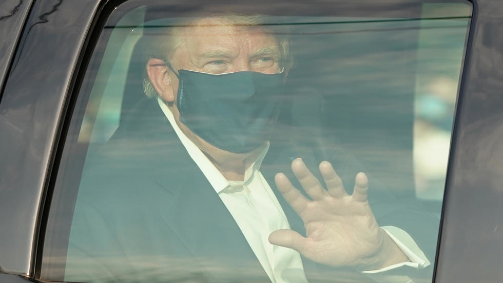 Trump saluda a sus partidarios desde una limusina en las afueras del hospital.