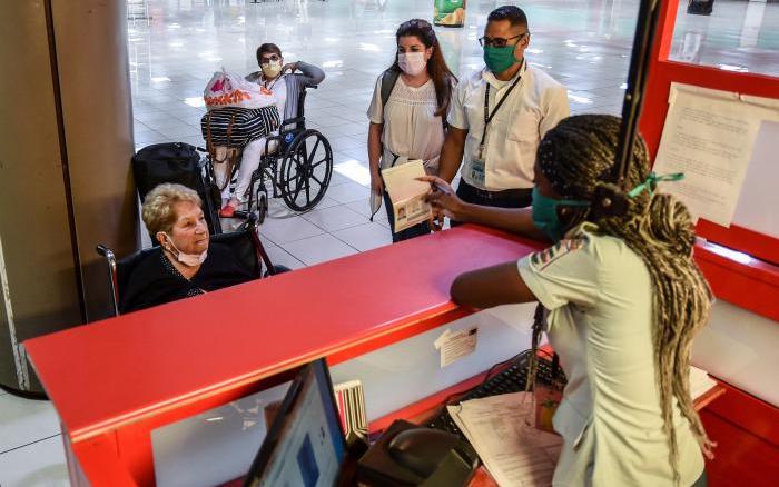 Una trabajadora de Migración recibe a viajeros en La Habana.