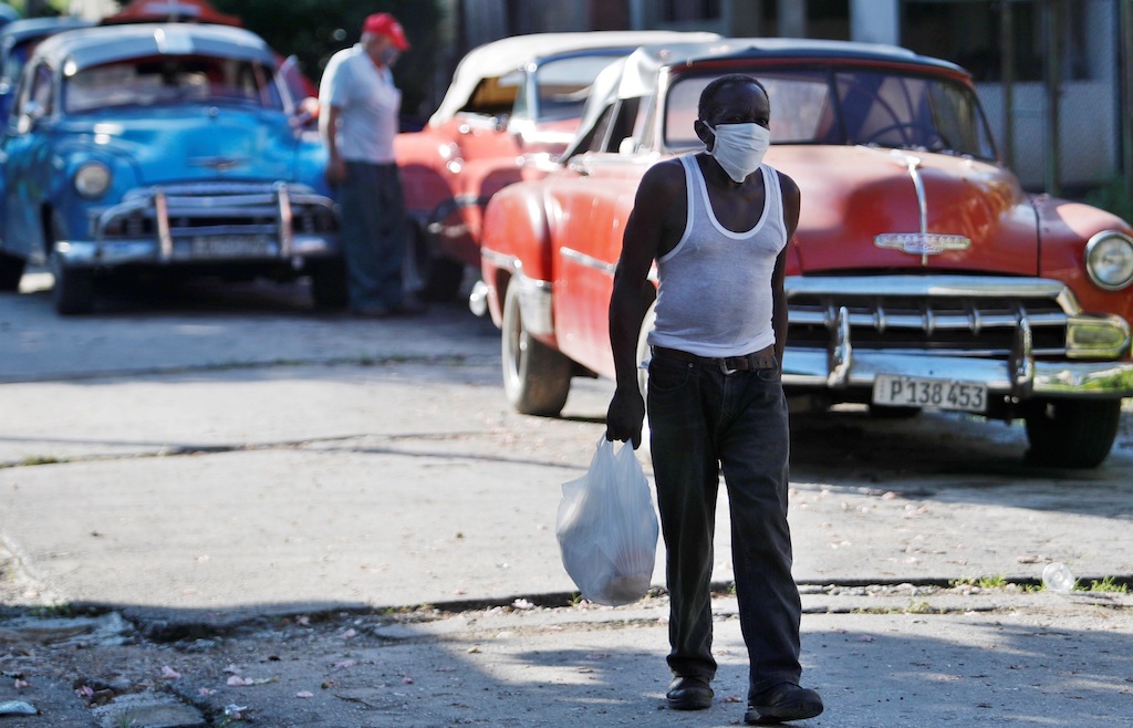 Un hombre usa nasobuco mientras camina por una calle de La Habana.
