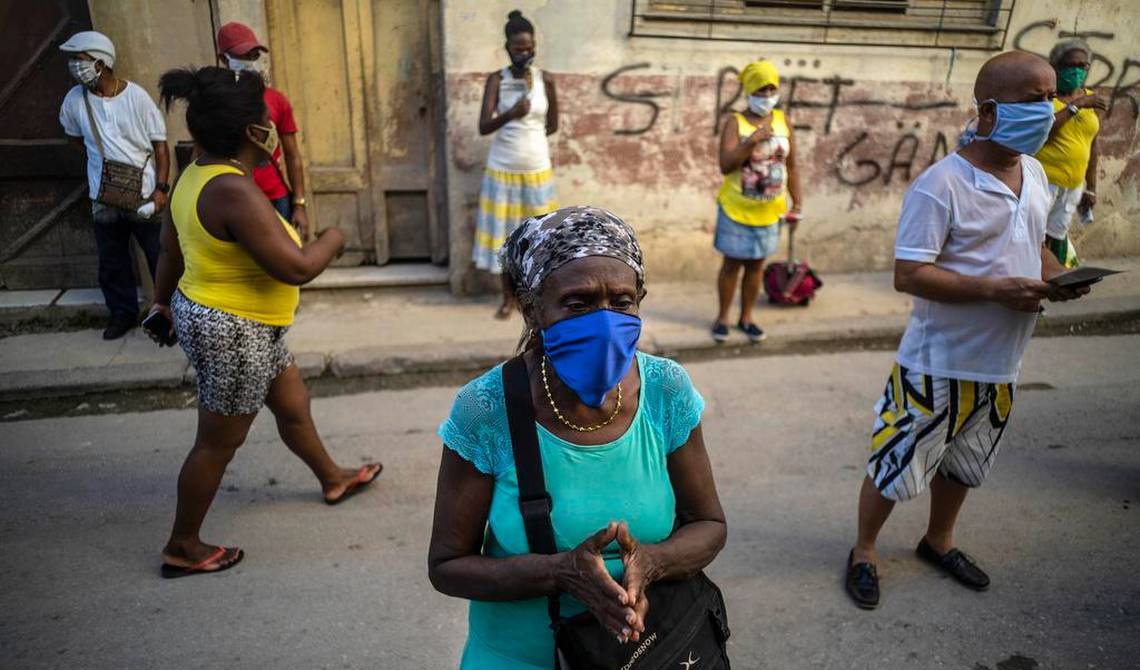 Un grupo de cubanos con nasobuco en la calle.