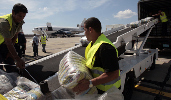 Trabajadores del aeropuerto descargan ayuda humanitaria.