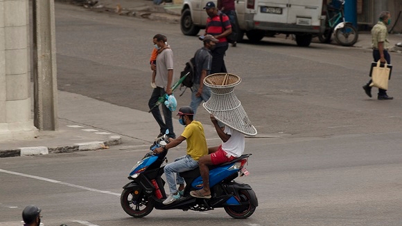 Unos cubanos trasladan una silla en La Habana, Cuba. 