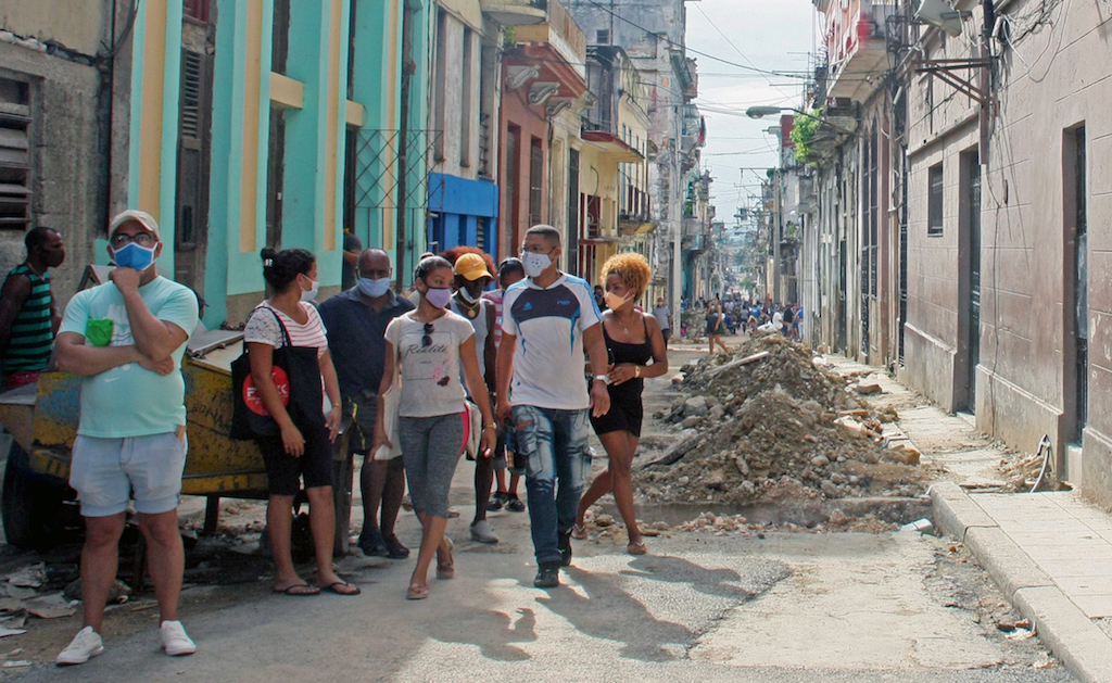 A group of Cubans walk down a street in Havana.