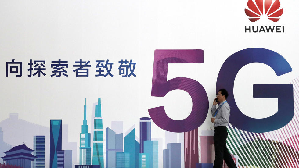 Un hombre camina delante de una publicidad sobre la tecnología 5G de Huawei en Pekín, China.