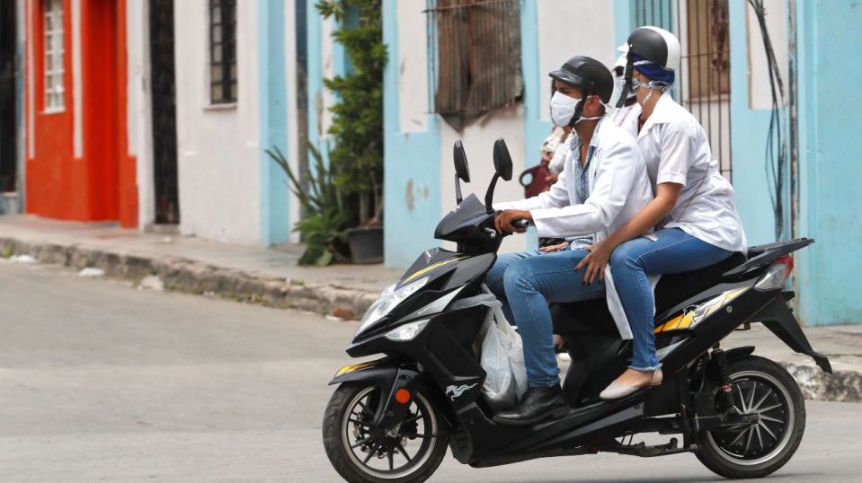 Dos médicos en una moto en La Habana.