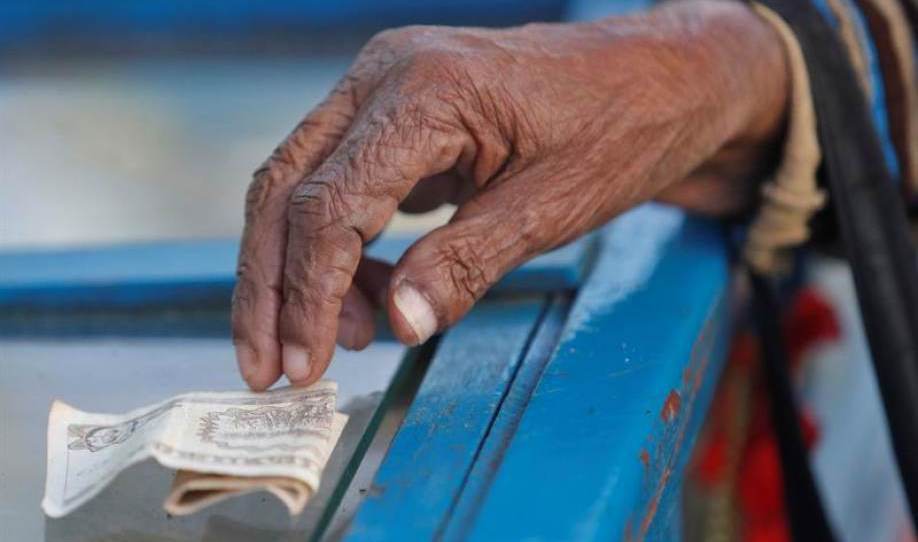 Un cliente paga hoy con un billete de pesos cubanos a un vendedor de dulces en Cuba.