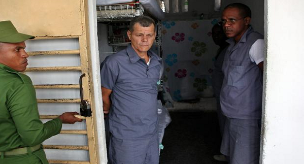 Dos reclusos junto a un funcionario de prisiones en la cárcel Combinado del Este, en La Habana.