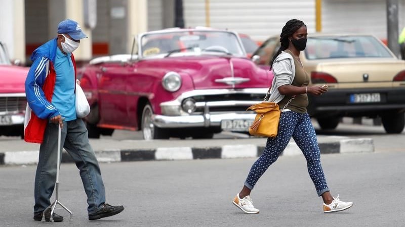 Dos personas cruzan una calle en La Habana.