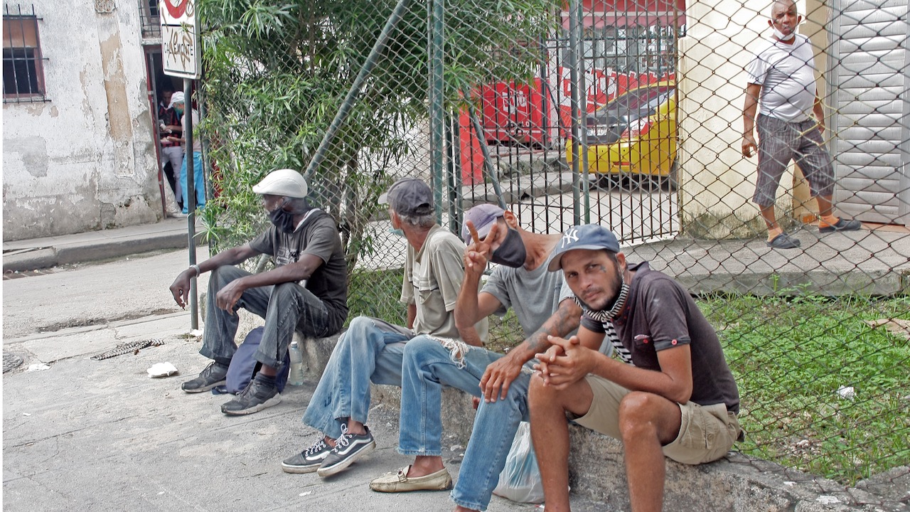 Un grupo de cubanos sentados en la calle.