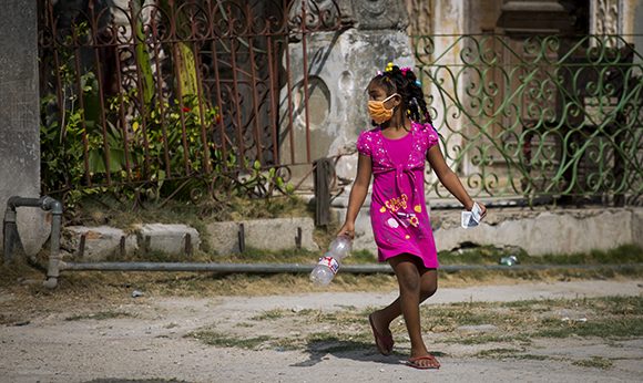 Una niña cubana con nasobuco en la calle.