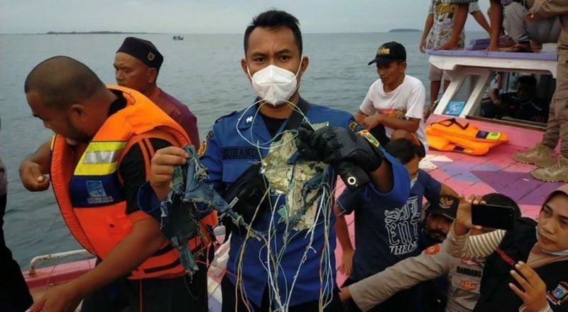 Un miembro de los equipos de rescate muestra restos que podrían ser del avión.