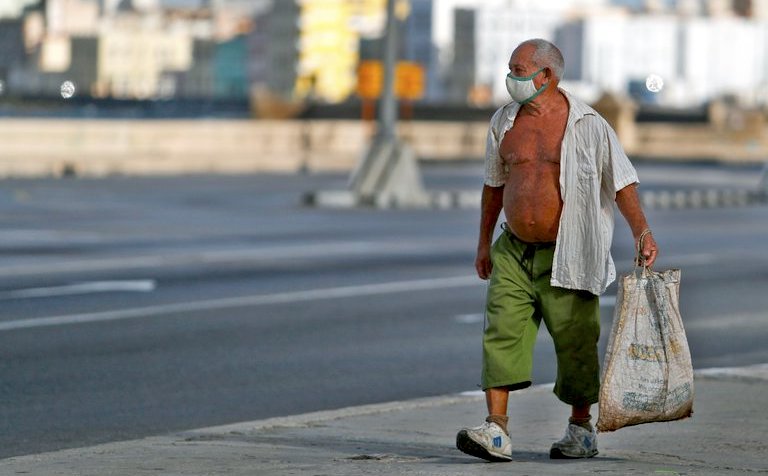 Un hombre camina por el Malecón habanero.