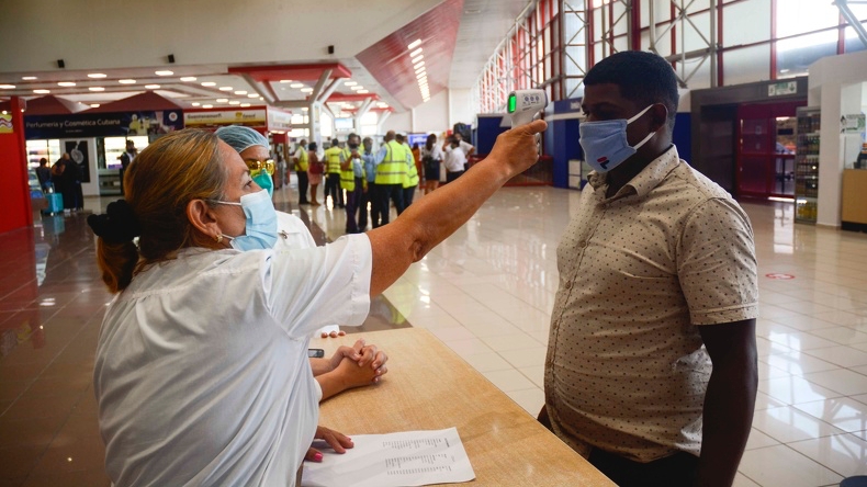 Una doctora toma la temperatura a un viajero en el aeropuerto de La Habana.