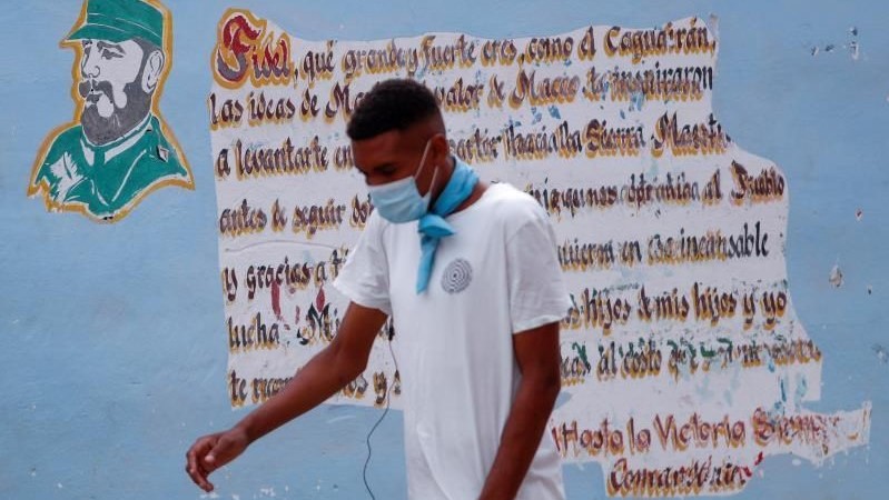 Un hombre pasa delante de una pared pintada con una frase de Fidel Castro.