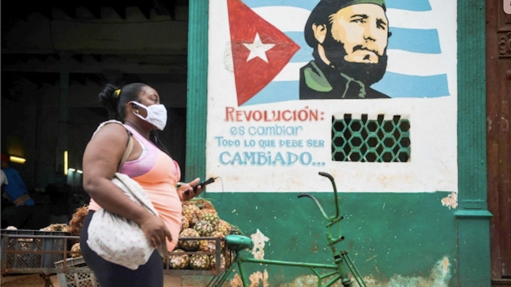 Una mujer pasa ante una imagen de Fidel Castro en La Habana.
