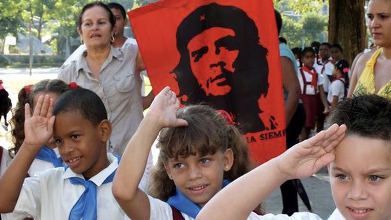 Pioneros cubanos bajo la imagen del 'Che' Guevara. 