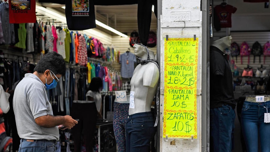 Un venezolano frente a una tienda con precios en dólares estadounidenses.