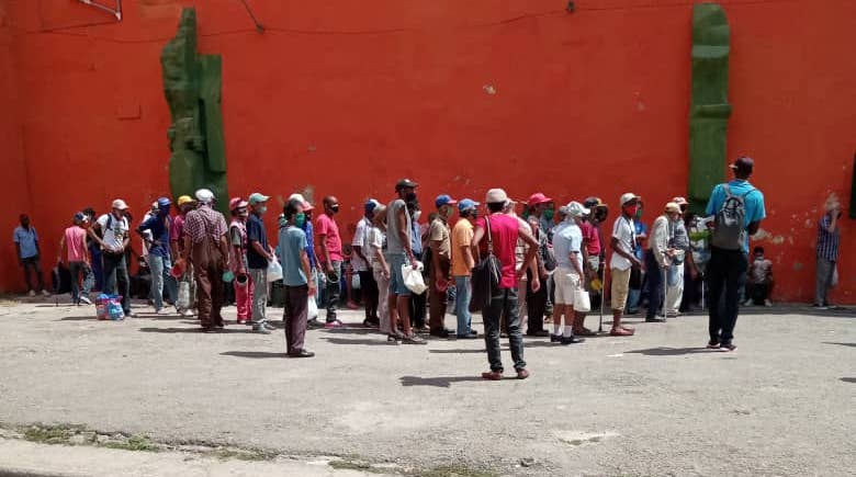 Ancianos y otros cubanos hacen cola en La Habana para recibir comida de la Seguridad Social.